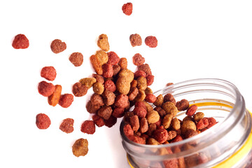 Pet Food Kibble Scattered from Jar Isolated on White Background
