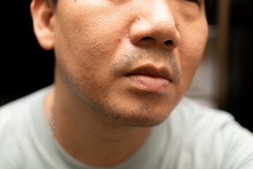 Obraz premium A detailed close up shot of the lower half of a man's face, highlighting his lips, nose, and stubble. The image focuses on skin texture.
