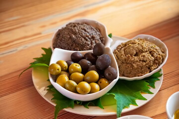 Olives and olive-based spreads on the wooden table