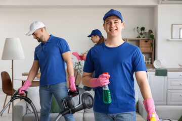 Male janitor with detergent in room