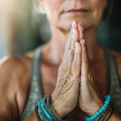 An elderly person is found meditating with hands joined in prayer, wearing beaded bracelets. The serene setting highlights a moment of reflection and tranquility, promoting inner peace.