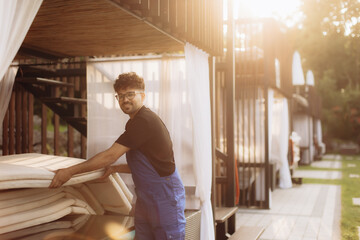 Hotel worker arranging beach mattresses at luxury resort