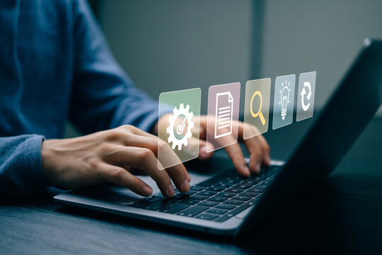 Man working on laptop with futuristic software icons representing various digital processes