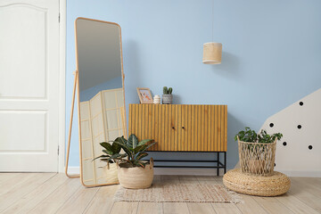 Interior of hallway with wicker baskets, mirror and plants