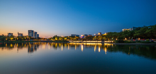 Fototapeta premium Captivating Twilight Reflections Over a Serene Urban Lake
