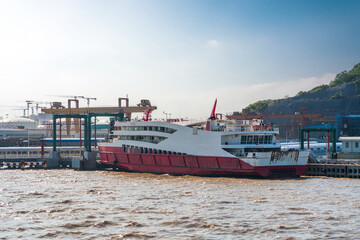 Rusty Ferry Docked at Port Amidst Sunny Cloudy Sky and Gentle Waves