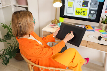 Female web designer working with graphic tablet at table in office