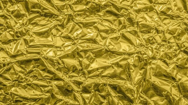 Luxury shiny metallic golden foil crumpled texture background stop motion
