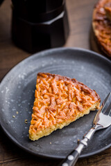Sweet almond pie on plate on wooden table.