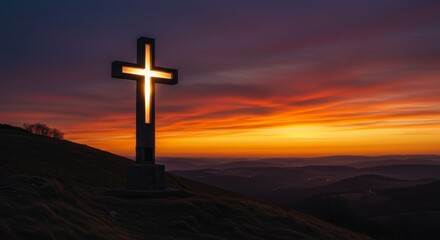 Glowing Christian cross standing on hill at sunrise or sunset
