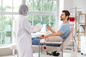 Obraz premium Young man donating blood with doctor in clinic