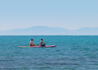 young couple   riding  on sup surfing in the sea at sumer time