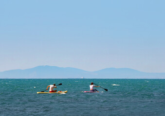 young couple   riding  on sup surfing in the sea at sumer time