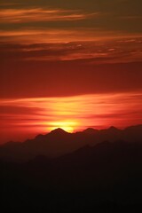 Obraz premium Fiery sunset over a mountain range.