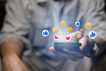 Close-up of man's hand using smartphone to play social media with emoticons or notifications popup.	
