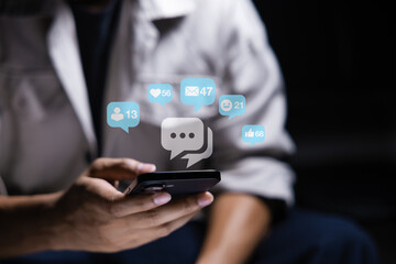 Close-up of man's hand using smartphone to play social media with emoticons or notifications popup.	
