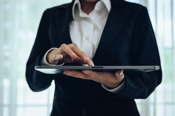 A professional businessman analyzes financial charts and stock market data on a digital tablet, focusing on investment strategy, economic growth, and global market trends for success.