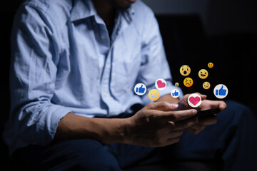 Close-up of man's hand using smartphone to play social media with emoticons or notifications popup.	
