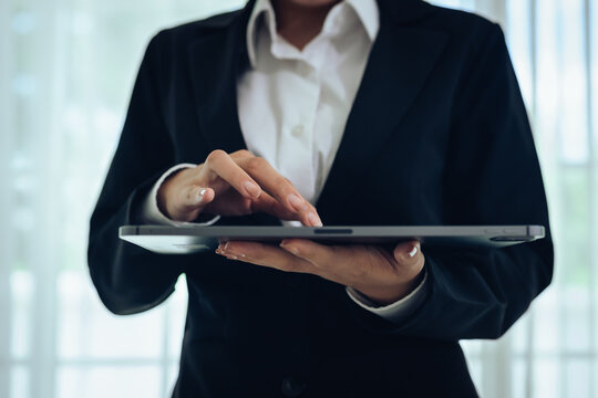 A professional businessman analyzes financial charts and stock market data on a digital tablet, focusing on investment strategy, economic growth, and global market trends for success.