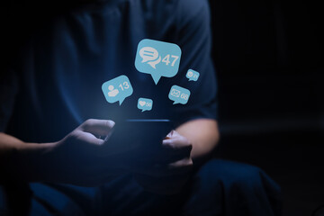 Close-up of man's hand using smartphone to play social media with emoticons or notifications popup.	
