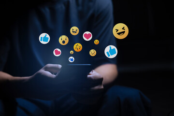 Close-up of man's hand using smartphone to play social media with emoticons or notifications popup.	
