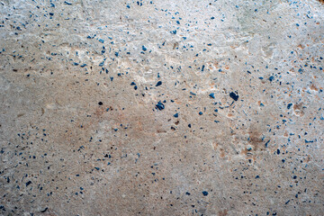 The concrete cement floor is dirty, has been washed and washed until the gravel is visible.