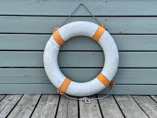 An orange and white lifebuoy hangs on the dock. High quality photo