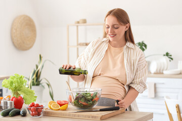 Young pregnant woman with oil preparing vegetable salad in kitchen