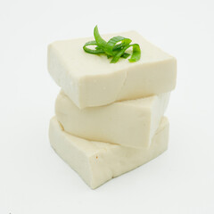 White Tofu on wooden plate, stacked, piled, isolated on white background