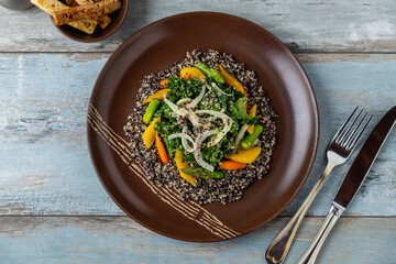 Top view of quinoa salad with orange, kale leaves and asparagus