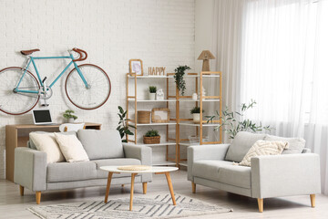 Interior of home office with workplace, bicycle and sofas