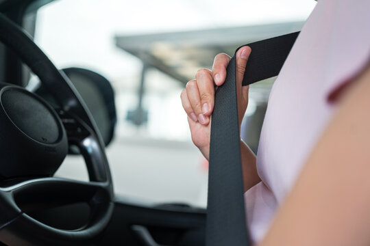 Action of a car driver is fastening seat belt and putting the buckle into slot before start driving. Transportation with safety concept scene, close-up and selective focus. 