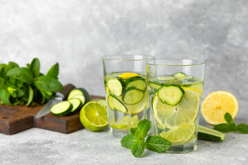 Cucumber water with lemon, lime and mint on a wooden table. Water infused with sliced...
