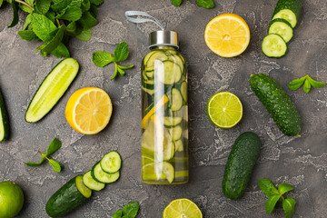 Cucumber water with lemon, lime and mint on a wooden table. Water infused with sliced...