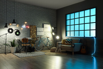 Interior of recording studio with synthesizer, sofa and glowing lamps at night