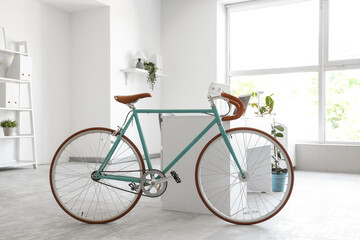 Modern bicycle near workplace in home office interior