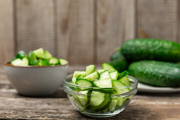 Cucumber on wooden background. Slice of cucumber on background. Fresh organic green cucumbers gherkin. Vegan. Salad ingredient. Farm vegetables. Cut vegetables with knife. Space for text. Copy space