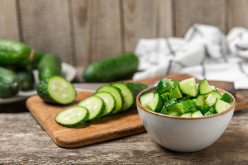 Cucumber on wooden background. Slice of cucumber on background. Fresh organic green cucumbers gherkin. Vegan. Salad ingredient. Farm vegetables. Cut vegetables with knife. Space for text. Copy space
