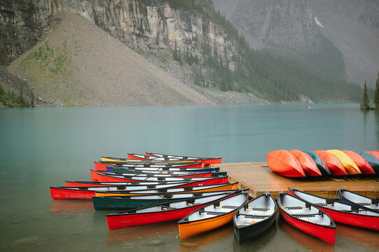 Colorful canoes lined up on dock at Moraine Lake, Banff