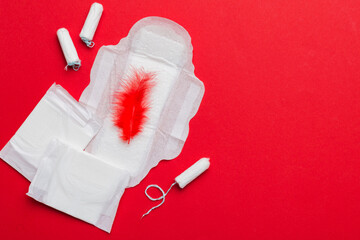 women pads and tampon - sanitary pads lies next to a tampon on an isolated background on a pink and...