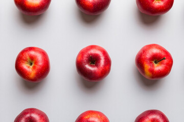 Many red apples on colored background, top view. Autumn pattern with fresh apple above view
