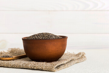 Chia seeds in bowl and spoon on colored background. Healthy Salvia hispanica in small bowl. Healthy...