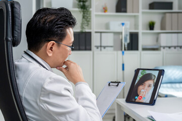 Asian doctor providing telehealth video consultation to online patient. 