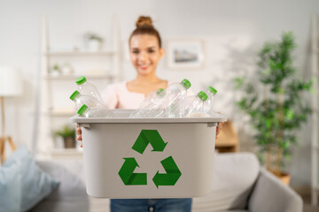 Portrait of Asian woman sorting plastic bottles for recycling at home. 