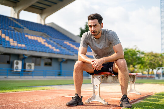 Caucasian man athlete taking a break while exercise outdoors at stadium. 