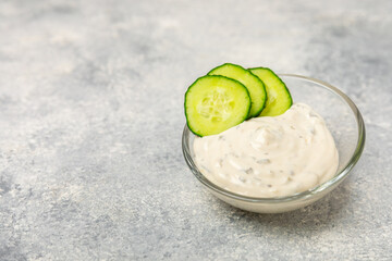 Cucumber sour cream tzatziki sauce on a wooden table.Tartar sauce. Traditional delicious appetizer....