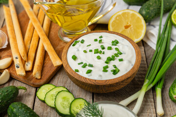 Cucumber sour cream tzatziki sauce on a wooden table.Tartar sauce. Traditional delicious appetizer....