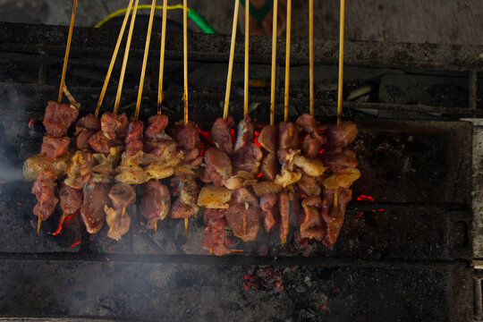 sate kambing or satay goat, lamb, Lamb or meat goat satay with charcoal ingredient on red fire grilling by people. traditional satay from yogyakarta, java, Indonesia cooking satay