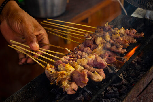 sate kambing or satay goat, lamb, Lamb or meat goat satay with charcoal ingredient on red fire grilling by people. traditional satay from yogyakarta, java, Indonesia cooking satay