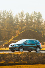 SUV on countryside drive in autumn light